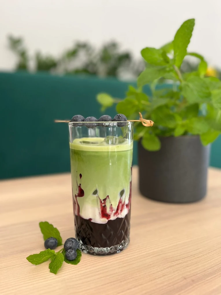 Matcha latte z jagodami i miętą w szklance